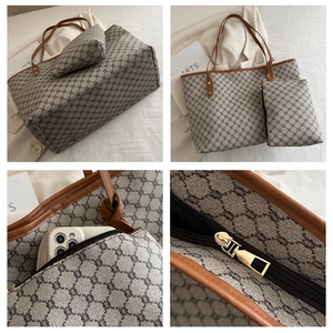 Detail of vintage tote bag set showing zipper closure and monogram pattern texture