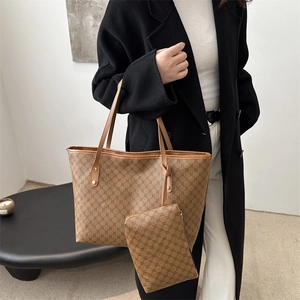 Detail of a brown monogram tote bag set with matching pouch and slim leather handles