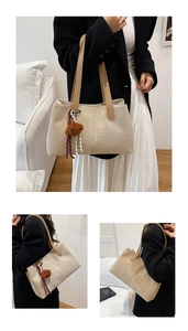 Dettaglio della borsa tote in tela beige con manici in pelle e ciondolo a forma di orsetto