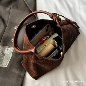 Vue de dessus montrant l'espace interne et le daim de ce petit sac à main marron