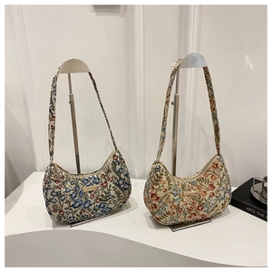 Detail of floral tapestry linen hobo bags featuring gold metal plates and shoulder straps