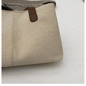 Dettaglio della trama in tela beige e cuciture del cinturino in pelle marrone