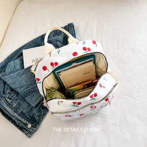 Détail du sac à dos motif cerise montrant la grande capacité pour tablette et livres