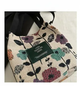 Detailed macro view of retro floral canvas bag with green leather patch and strap