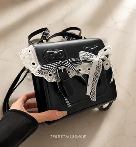 Close-up of black lace backpack with dual bows and elegant metal buckle detail