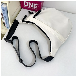 Detailopname van witte nylon crossbodytas met zwarte rits en duurzame schouderband
