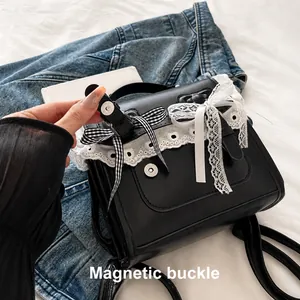 Detail showing the magnetic buckle closure and lace trim on a black leather backpack