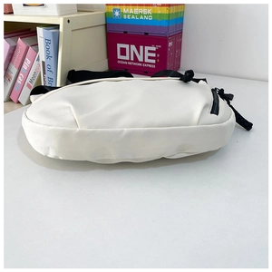 Detailweergave van witte halve maan tas van waterdicht nylon met zwarte rits en riem