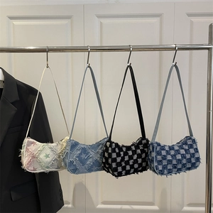Chic distressed denim underarm bags with star and checkerboard prints hanging on display