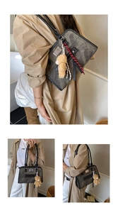 Detail der grauen Vintage-Umhängetasche mit Lederbesatz und Plüschbären-Anhänger