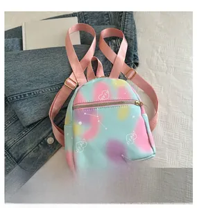Close-up of mini nylon backpack featuring pastel gradient dye and white heart embroidery