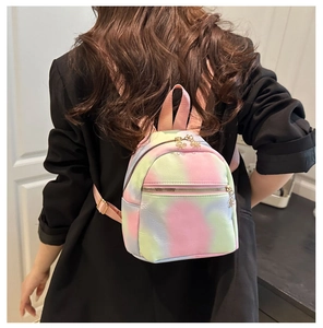 Detail of mini tie-dye nylon backpack featuring petal zipper charms and pink straps