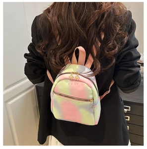 Detail of pink and green tie-dye nylon backpack with flower zipper on the front pocket