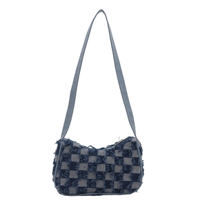 Dark blue denim checkerboard underarm bag with frayed tassel edges and crossbody strap