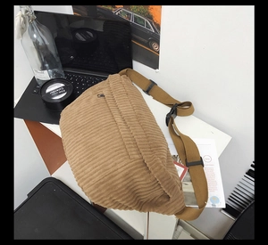 Détail de la texture en velours côtelé kaki sur un sac à bandoulière avec sangle nylon