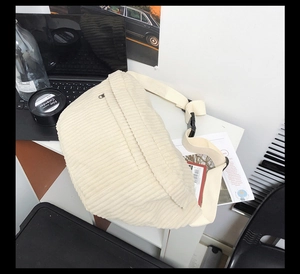 Détail de la sacoche en velours côtelé beige montrant la texture et la boucle noire