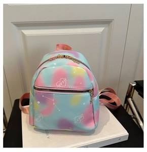 Close-up of heart embroidery on gradient nylon backpack with gold zipper detail