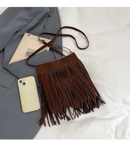 Detailed close-up of brown suede crossbody bag with long tassels showing texture and size
