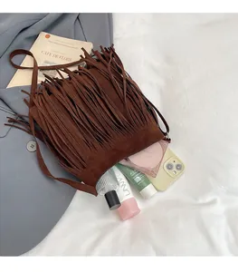 Detailed view of dark brown suede tassel bucket bag showing spacious interior storage