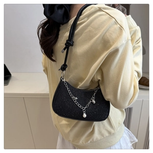 Détail du sac hobo noir scintillant avec chaîne argentée, perle et breloque étoile
