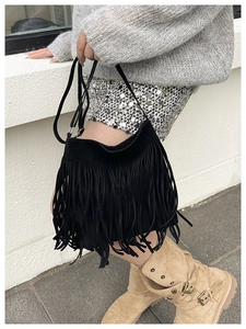 Sac seau noir à franges tendance avec texture mate présenté en style urbain extérieur