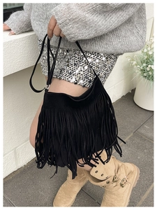 Vue détaillée du sac seau noir en daim mat orné de longues franges style bohème