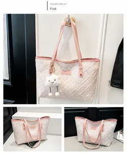 Pink quilted tote bag with leather straps and cloud plush charm detail view