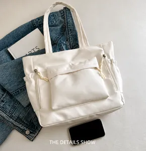 Detailansicht der weißen Kunstleder-Tragetasche mit großer Vordertasche und Reißverschluss