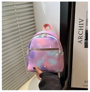 Detail of gradient mini backpack featuring star patterns and floral zipper pulls