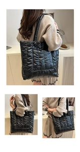 Detail of a large black quilted tote bag showing its puffer texture and spacious design