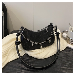 Détail du sac hobo noir pailleté avec breloques étoiles et perles sur chaîne argenté