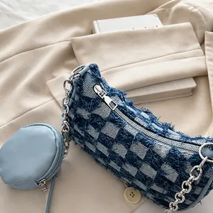 Close-up of blue denim checkerboard bag with metal zipper and mini coin pouch detail