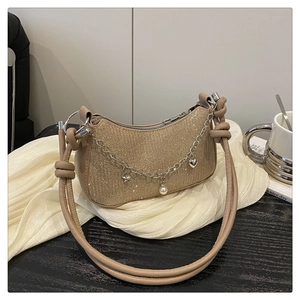 Détail du sac lune à paillettes or champagne avec breloques étoile et cœur sur chaîne