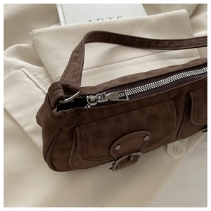 Close-up of durable metal zipper and premium suede texture on a vintage brown shoulder bag