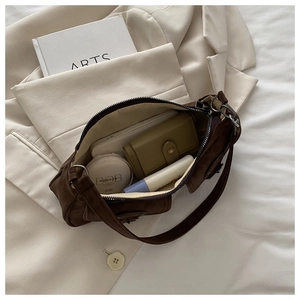 Interior view of brown underarm bag showing capacity for phone and cosmetics