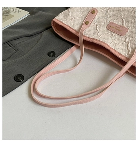 Detail of pink leather trim and star embroidered jacquard fabric on the tote bag