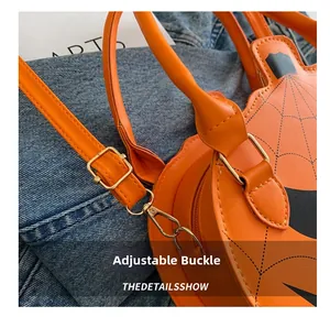 Close-up of adjustable strap buckle and spider web pattern on orange pumpkin bag
