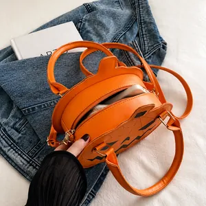 Detail view of the spacious interior of the orange pumpkin crossbody bag with a phone