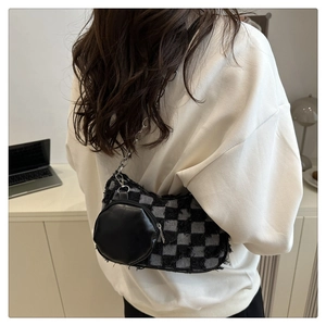 Detail view of denim checkerboard star bag with silver chain and mini coin pouch