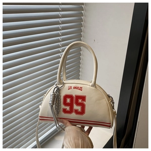 Detail of white leather tote bag featuring red Los Angeles print and silver chain strap