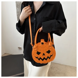 Orange pumpkin crossbody bag with black spider web detail worn by a fashion model