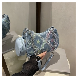 Détail du sac croissant en denim avec motifs d'étoiles effilochés et chaîne argent