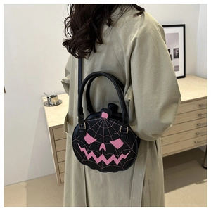 Detailed back view of a black pumpkin cross-body bag with pink spider web pattern