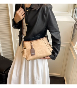 Detail of khaki bucket bag with contrast brown trim and fashion tag on side pocket