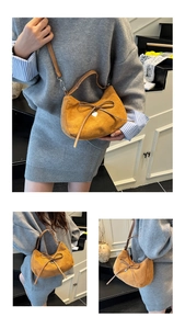 Close-up of caramel suede tote bag with delicate bow tie and silver heart charm detail
