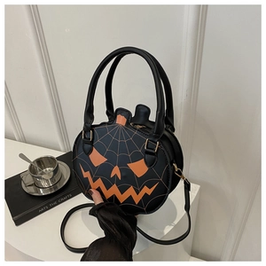 Detail of Jack-o'-lantern pumpkin bag with orange face print and gold hardware