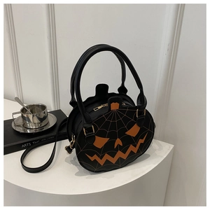 Detail of Halloween pumpkin crossbody bag with orange spider web embroidery and face