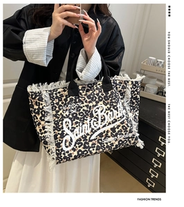 Detalle macro del bolso tote de leopardo con bordes de flecos y textura de lona