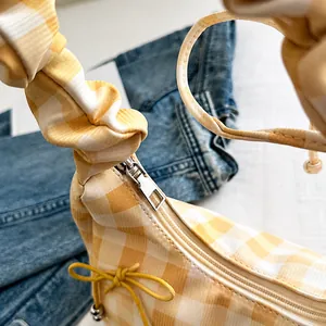 Detail der gelb karierten Tasche mit glattem Silber-Reißverschluss und Falten-Schultergurt