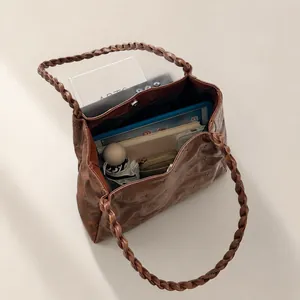 Detail display of large capacity tote bag holding tablet, books and umbrella